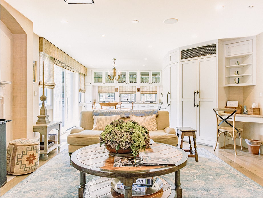 Cozy living area in a modern Vail condominium with a comfortable sofa, round coffee table, and bright kitchen space, showcasing a welcoming alpine atmosphere at RamsHorn Lodge.